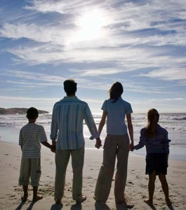 Young Couple with Two Children (8-12) Walking on the Beach